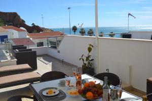 a table with a bowl of fruit on a balcony at Duplex - Varandas Do Mar Patricia in Albufeira