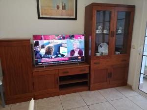 TV a schermo piatto in un centro di intrattenimento in legno di ORLANDO RESORT Playa Las Américas ad Adeje