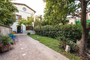 een bakstenen pad voor een huis met een boom bij La Villetta in Sorrento