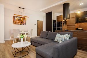 a living room with a couch and a table at Apartments Rzeczypospolitej by Renters Prestige in Warsaw
