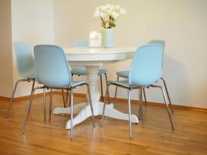 a table with four chairs and a table with a vase of flowers at APSTAY City Residence Apartments ǀ Parking option & Self Check-in in Graz