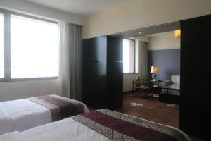 ein Hotelzimmer mit 2 Betten und einem Spiegel in der Unterkunft Hotel Landmark Canton in Guangzhou