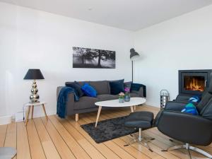 a living room with a couch and a fireplace at 4 person holiday home in Ebeltoft in Ebeltoft