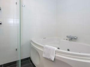 a white bath tub in a bathroom with a towel at 4 person holiday home in Ebeltoft in Ebeltoft