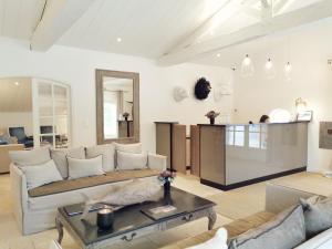 a living room with a couch and a table at Le Clos Saint-Martin Hôtel & Spa in Saint-Martin-de-Ré