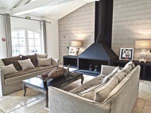 a living room with two couches and a fireplace at Le Clos Saint-Martin Hôtel & Spa in Saint-Martin-de-Ré