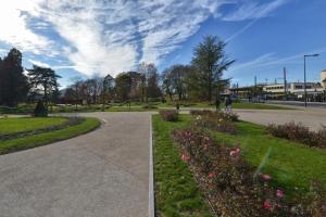 un parque con una pasarela y flores en un parque en Appartment Les Suites Du Parc en Besançon