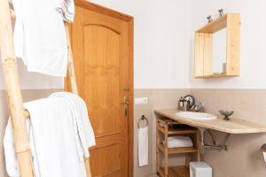 a bathroom with a sink and a wooden door at APARTAMENTO EL ROJO in Can Picafort