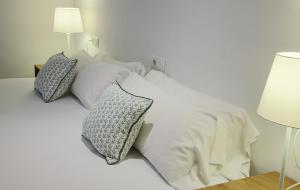 un letto bianco con due cuscini sopra di APARTAMENTO EL ROJO a Can Picafort