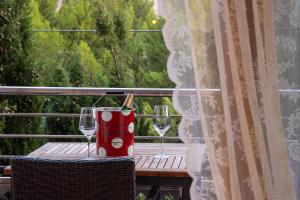 a table with two wine glasses on a balcony at APARTAMENTO EL ROJO in Can Picafort