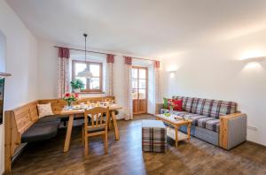 a living room with a couch and a table at Beim Paulfischer - Eckbankerl in Chieming