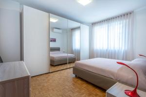 una camera con letto e specchio di Udine Palazzo d'Aronco Modern Apartment a Udine