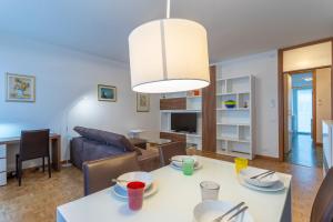 un soggiorno e una sala da pranzo con tavolo e divano. di Udine Palazzo d'Aronco Modern Apartment a Udine