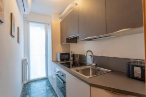 una piccola cucina con lavandino e forno a microonde di Udine Palazzo d'Aronco Modern Apartment a Udine