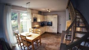 a kitchen with a table and chairs and a staircase at Bernsteininsel in Thiessow