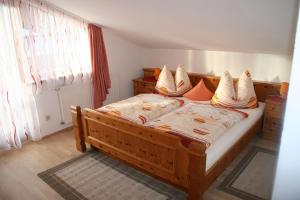 1 dormitorio con cama de madera y almohadas en Ferienwohnungen Haus Mooswinkel, en Weerberg