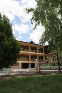 a large building with trees in front of it at Xenonas Platia in Kato Loutraki