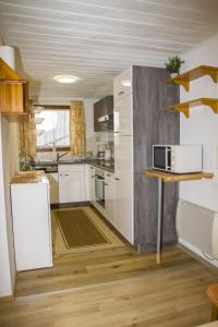 cocina con armarios blancos y nevera blanca en Ferienwohnungen Haus Mooswinkel, en Weerberg