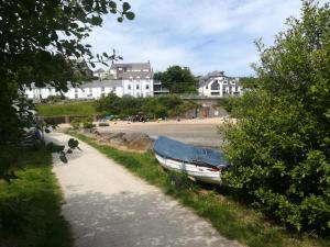 a boat parked on the side of a path next to a beach at Rooms at The Highcliffe in Aberporth