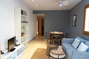 ein Wohnzimmer mit einem blauen Sofa und einem Tisch in der Unterkunft EL ROJO 2 in Can Picafort