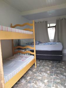 Ce dortoir comprend 2 lits superposés et une fenêtre. dans l'établissement Pousada Margareth, à Ilha do Mel