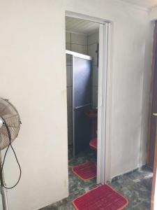 a bathroom with a door open to a refrigerator at Pousada Margareth in Ilha do Mel