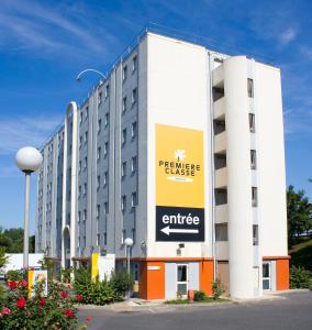 a large building with a sign on the side of it at Premiere Classe Le Blanc Mesnil in Le Blanc-Mesnil