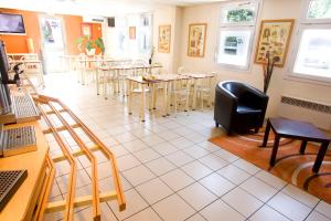 a restaurant with tables and chairs in a room at Premiere Classe Le Blanc Mesnil in Le Blanc-Mesnil