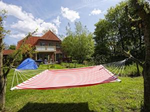a hammock in a yard in front of a house at Ferienhof Augustenhöhe in Fehmarn