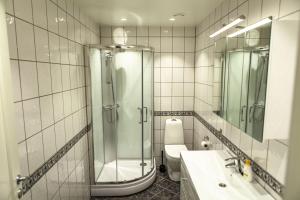 a bathroom with a shower and a sink and a toilet at Forenom Serviced Apartments Bergen City in Bergen