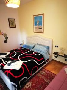 Schlafzimmer mit einem Bett mit einem schwarzen und roten Teppich in der Unterkunft Civico 22 Pisa in Pisa
