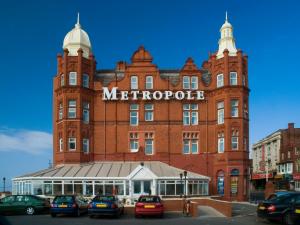 ein großes rotes Backsteingebäude mit einem Schild darauf in der Unterkunft The Metropole Hotel in Blackpool