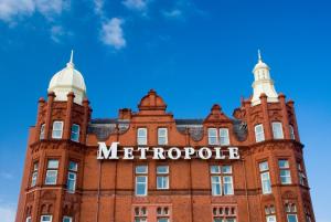 a large brick building with a clock on the front of it at The Metropole Hotel in Blackpool
