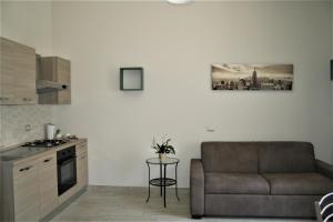 a living room with a couch and a kitchen at Altavilla Holiday House in Tivoli