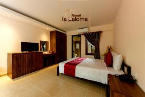 Habitación de hotel con cama y TV en La Paloma Resort, en Phu Quoc
