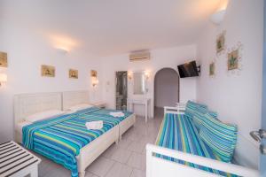 a bedroom with two beds and a television in it at Vardia Bay Studios in Karavostasi