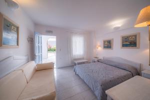 a bedroom with a bed and a couch and a table at Vardia Bay Studios in Karavostasi