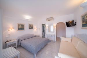 a bedroom with a bed and a couch at Vardia Bay Studios in Karavostasi