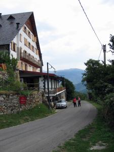 dos personas caminando por un camino al lado de un edificio en Hotel Terralta, en Campelles