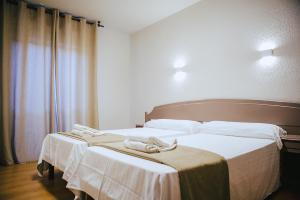 Dos camas en una habitación de hotel con toallas. en Hotel Ducay, en Olite