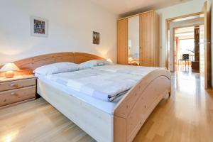 1 cama grande en un dormitorio con cabecero de madera en Katharinenhof Ferienwohnung Kramer Groß (3), en Garmisch-Partenkirchen