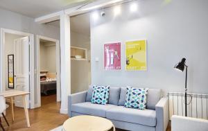 a living room with a blue couch and a table at Bergara Apartment by BasqueHomes in San Sebastián