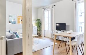 uma sala de estar branca com uma mesa e um sofá em Bergara Apartment by BasqueHomes em San Sebastián