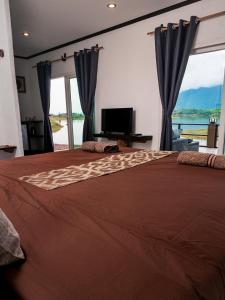 a bedroom with a large bed with a large window at Green View Resort in Vang Vieng