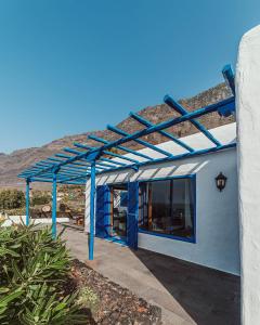 una pérgola azul en el lateral de un edificio en Villa Juan, en Las Puntas
