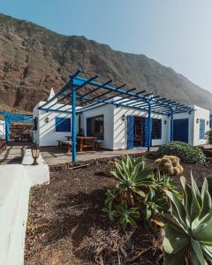 una casa azul y blanca con una montaña en el fondo en Villa Juan, en Las Puntas