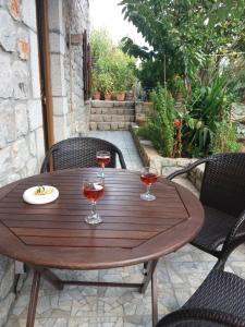 a wooden table with two glasses of wine on a patio at Katerinas Guest House in Leonidio