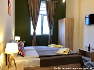 a bedroom with a large bed with a window at SKYLER GUEST HOUSE in Plovdiv