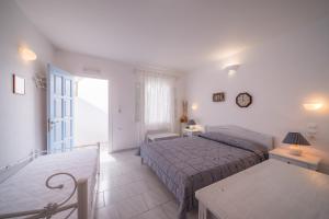 a bedroom with a bed and a table and a window at Vardia Bay Studios in Karavostasi