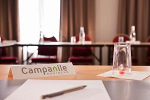 une table avec un panneau indiquant campania business dans l'établissement Campanile Epône, à Épône
